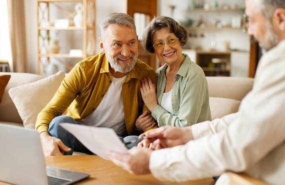 Happy couple talking with insurance agent.